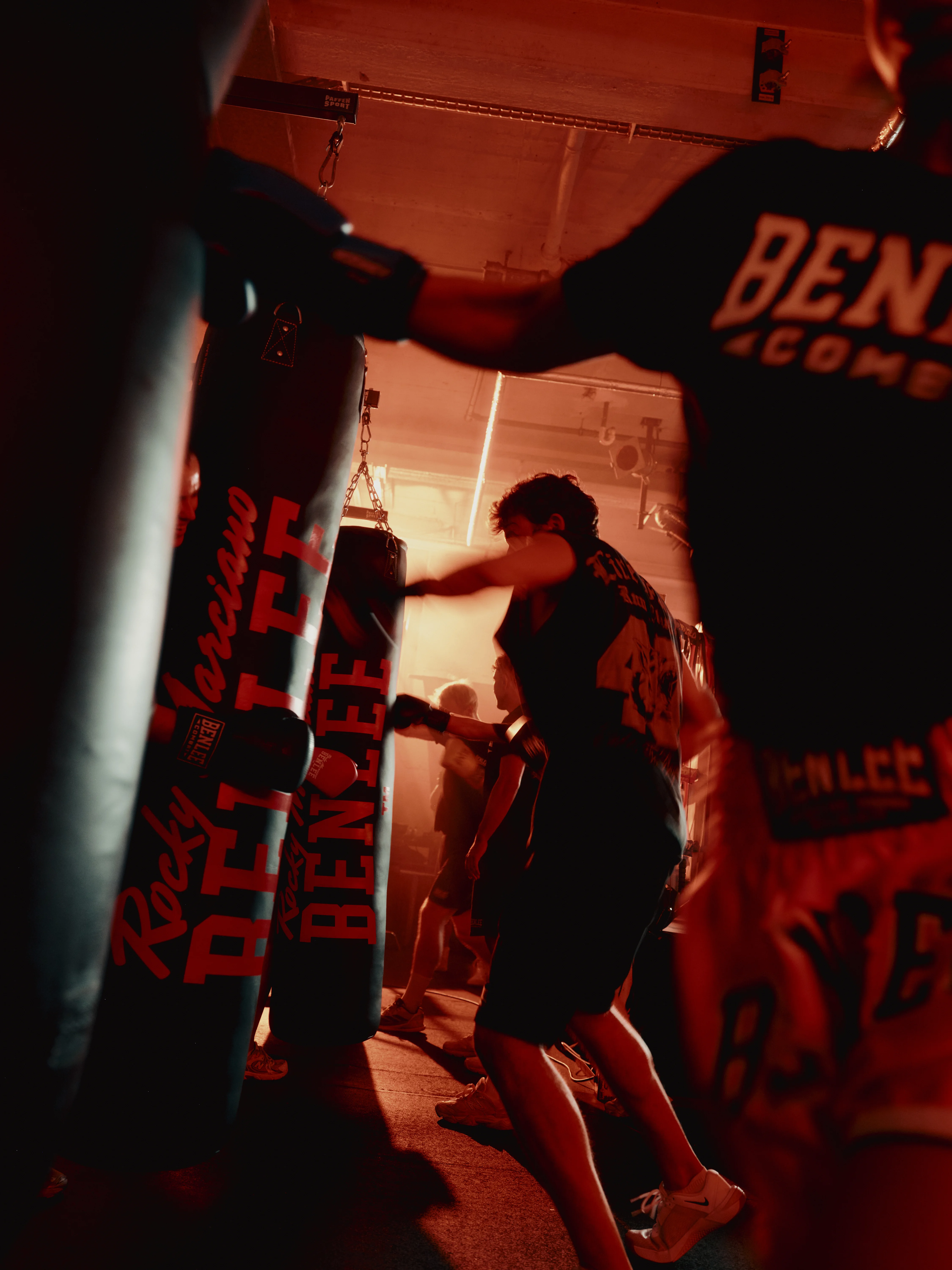 Participants training at heavy bags in red light