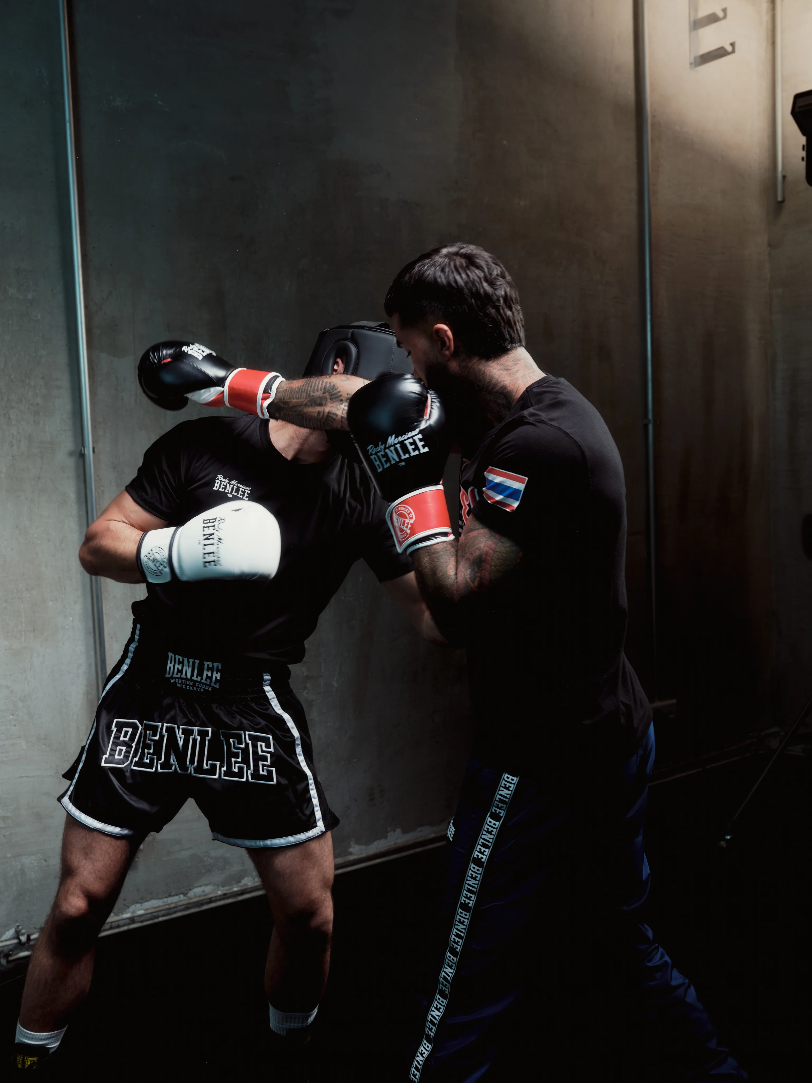Two boxers sparring against a concrete wall