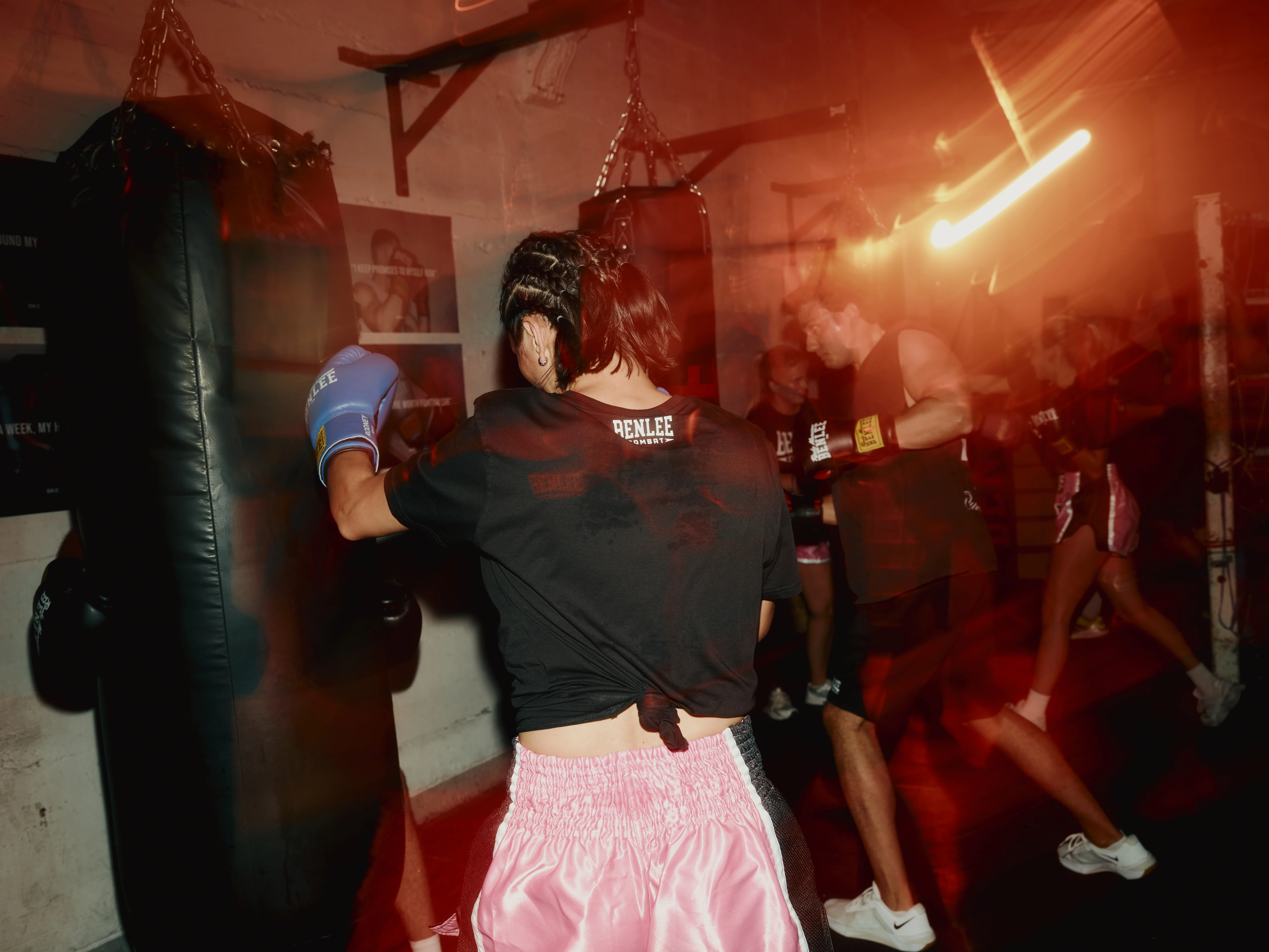 Boxer in blue gloves hitting a heavy bag