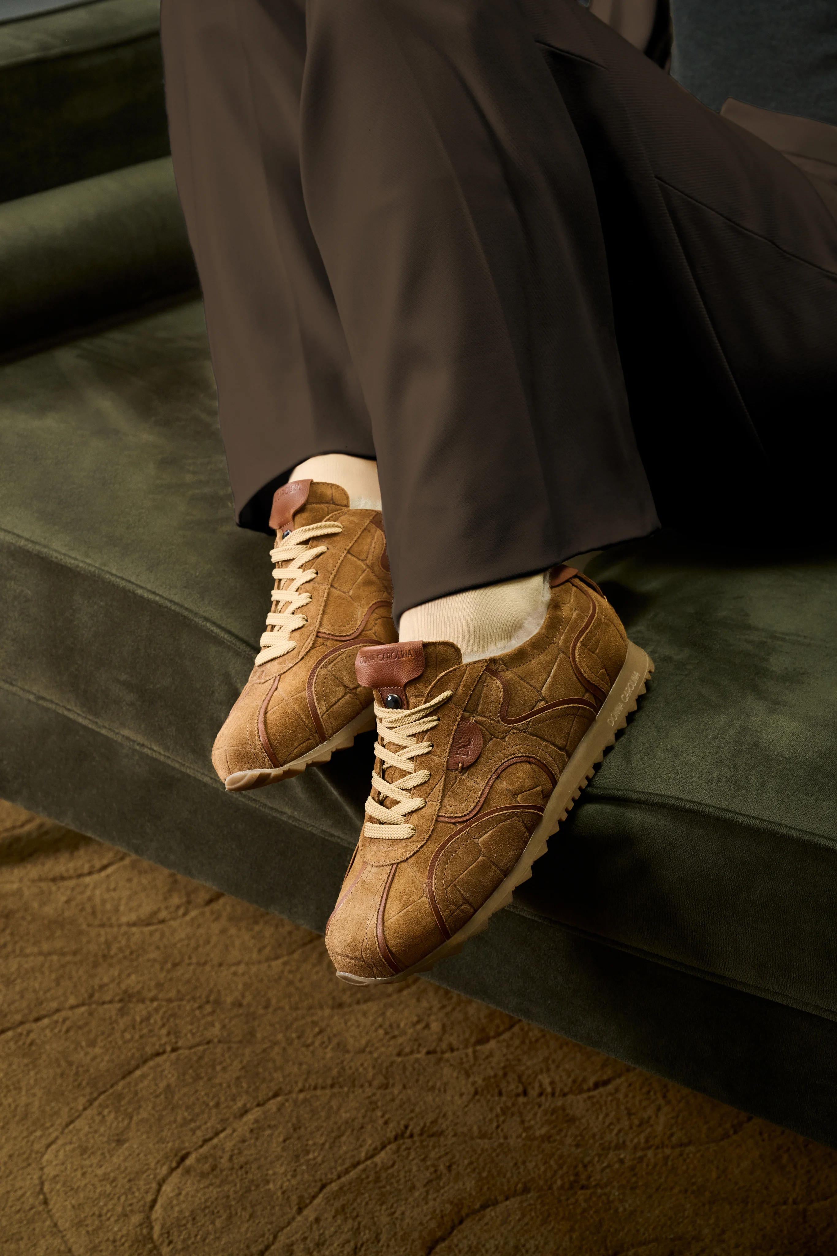 Camel suede sneakers with a shearling lining on a green velvet sofa