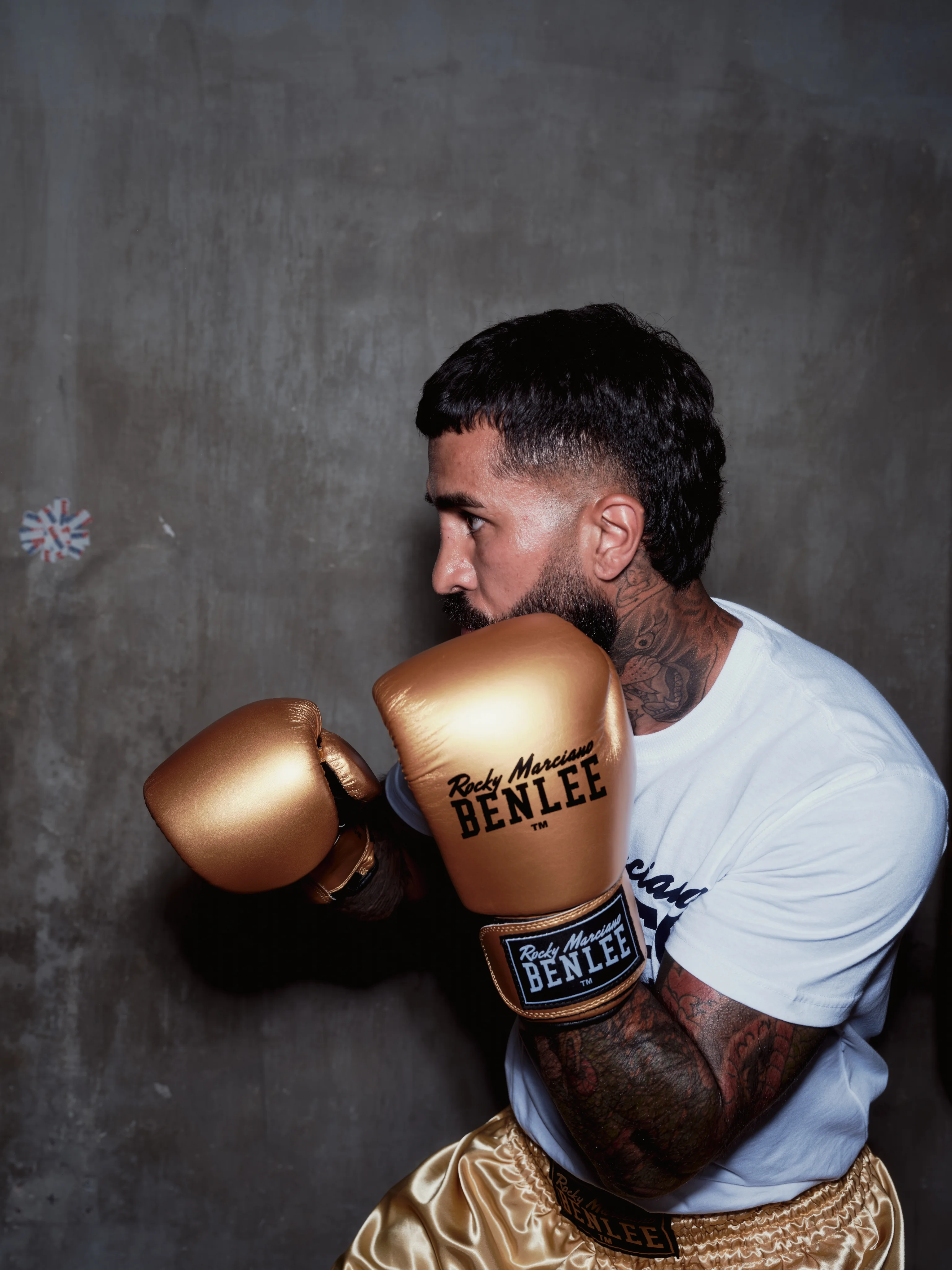 Boxer in gold gloves and a white BENLEE T-shirt
