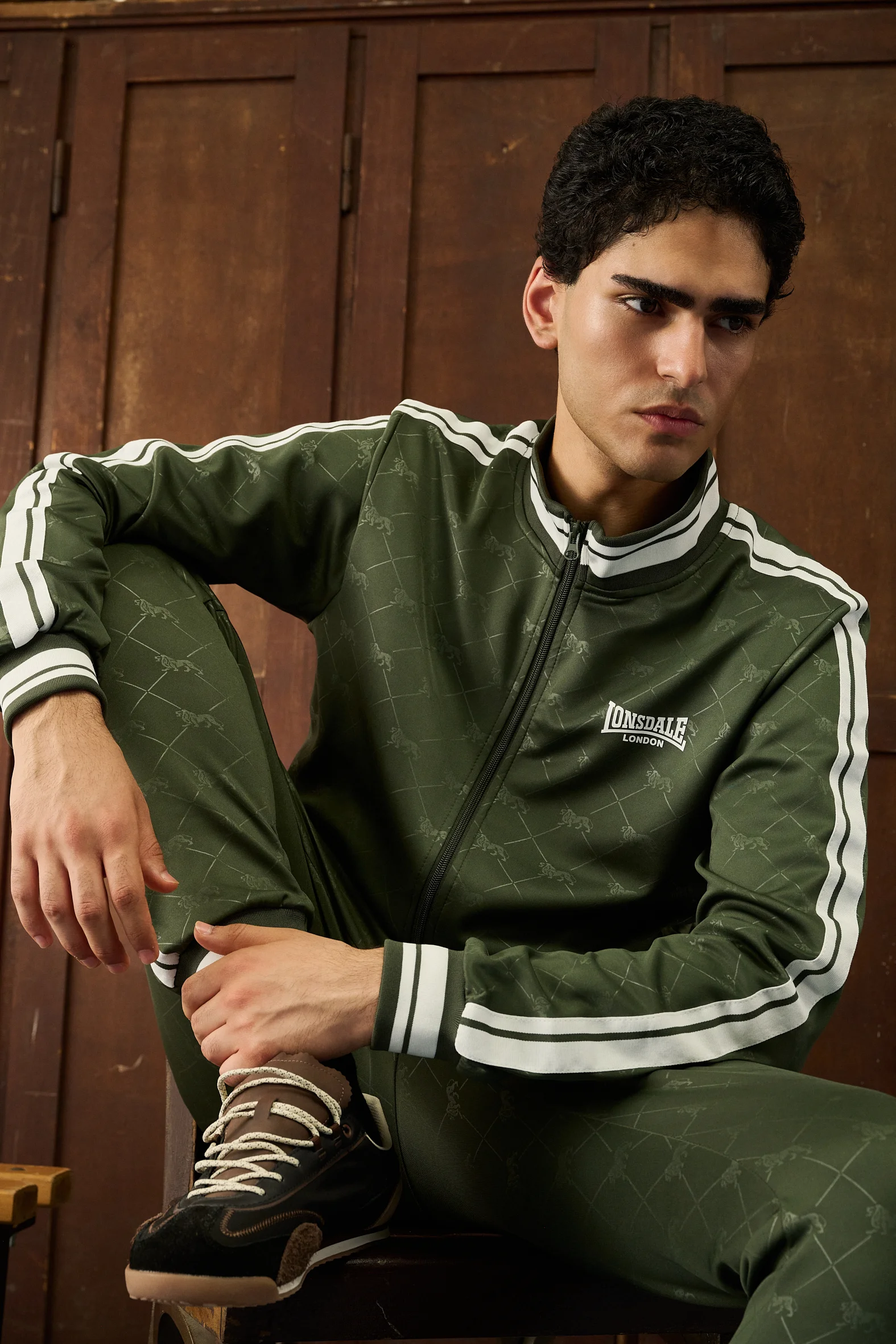 Man in a green Lonsdale tracksuit sitting, close-up