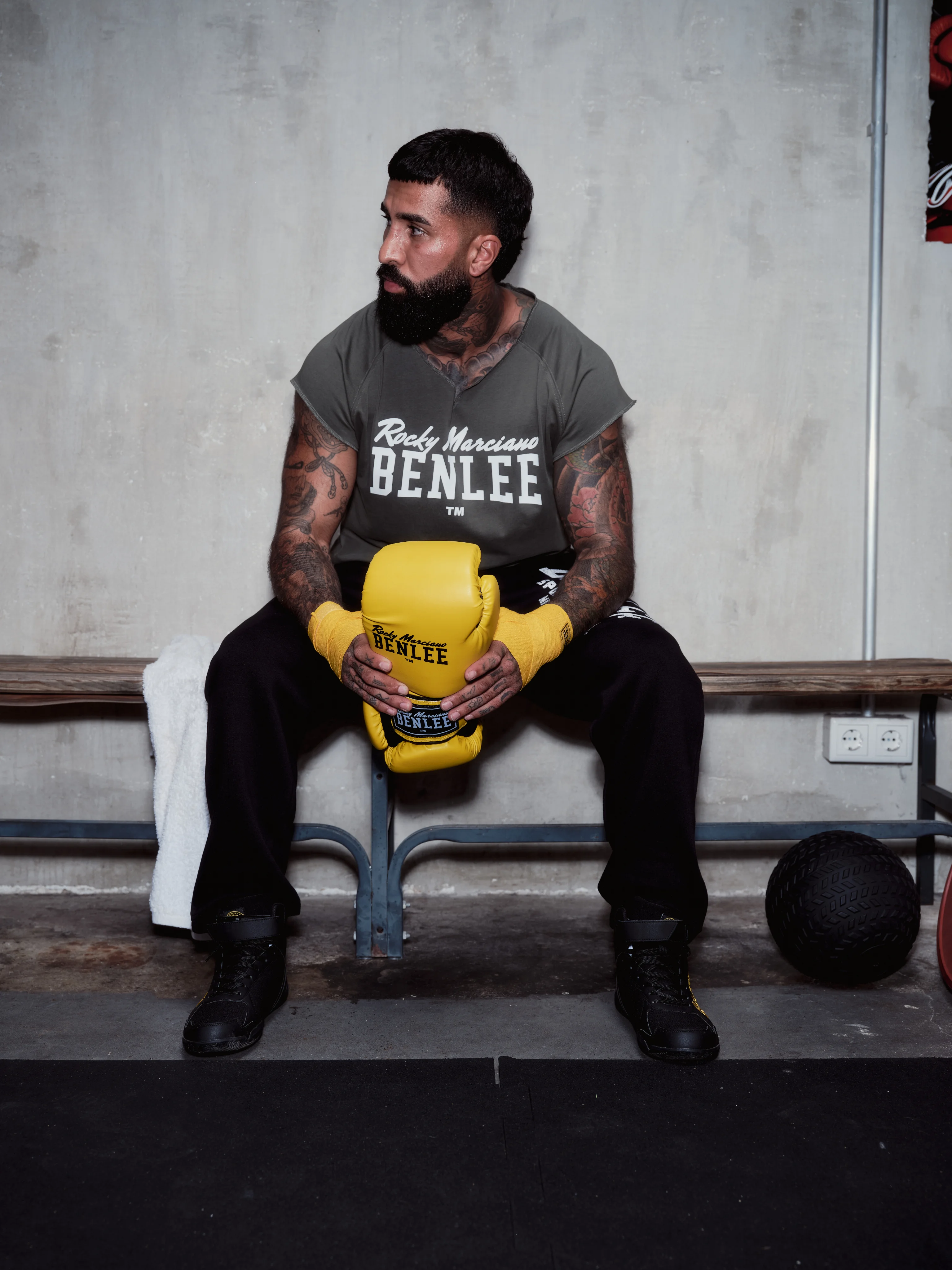 Boxer with yellow gloves sitting on a bench