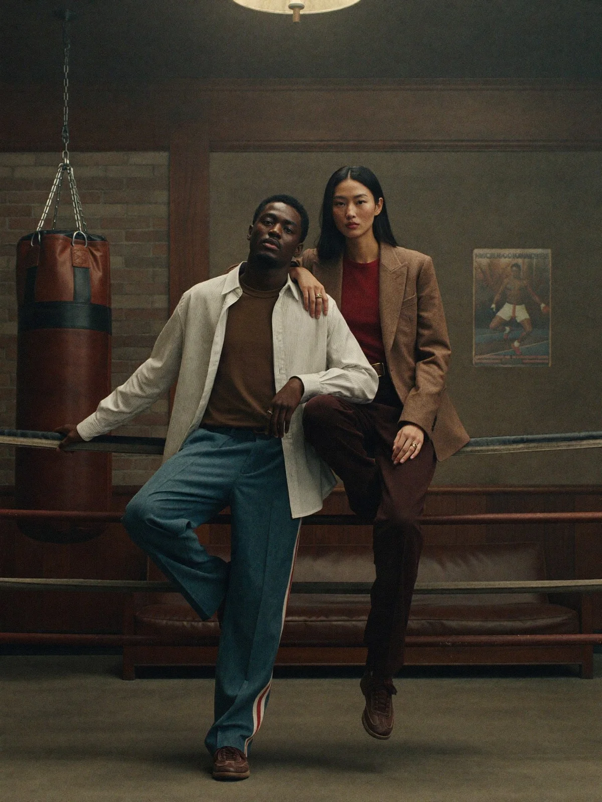 Two models in tailored outfits in a boxing gym