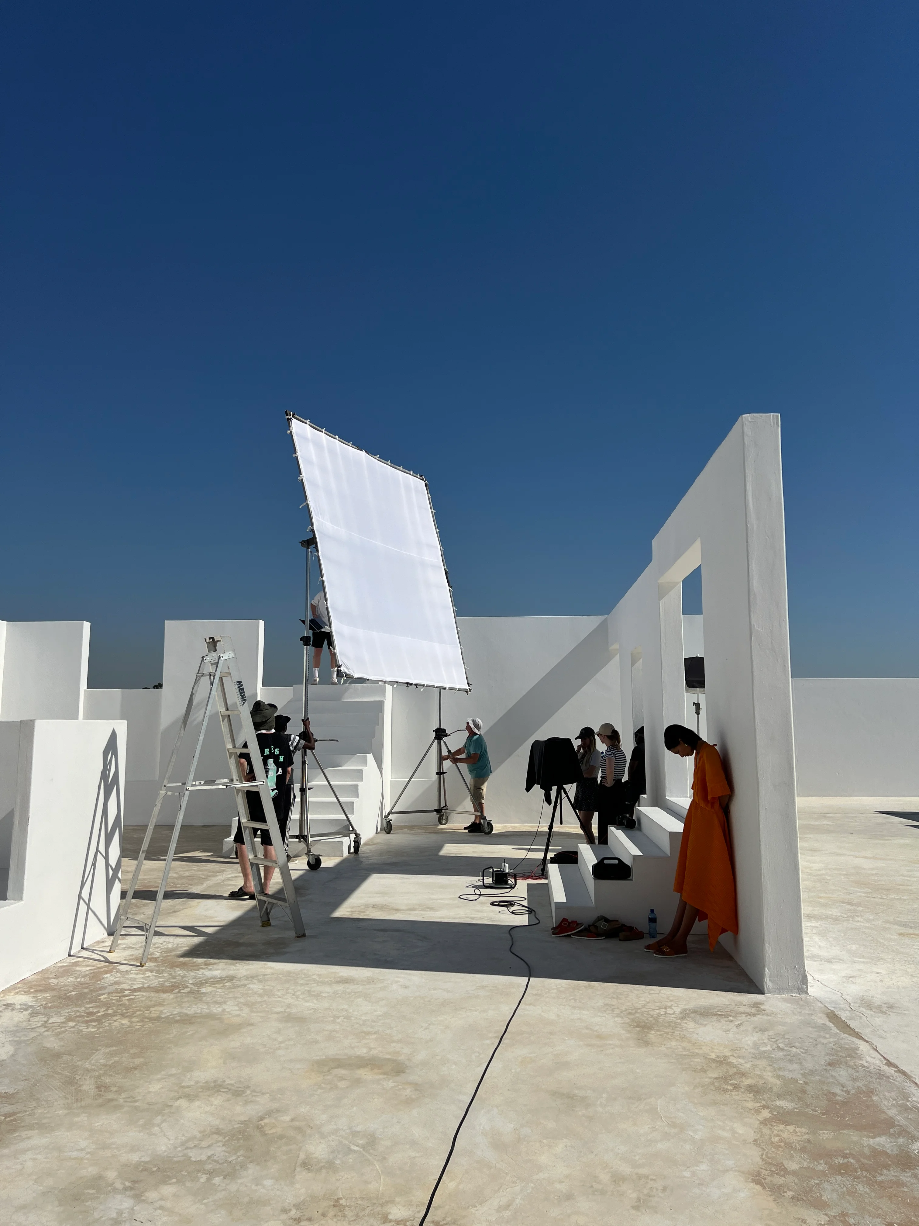 Lights and a reflector set up on a white rooftop location