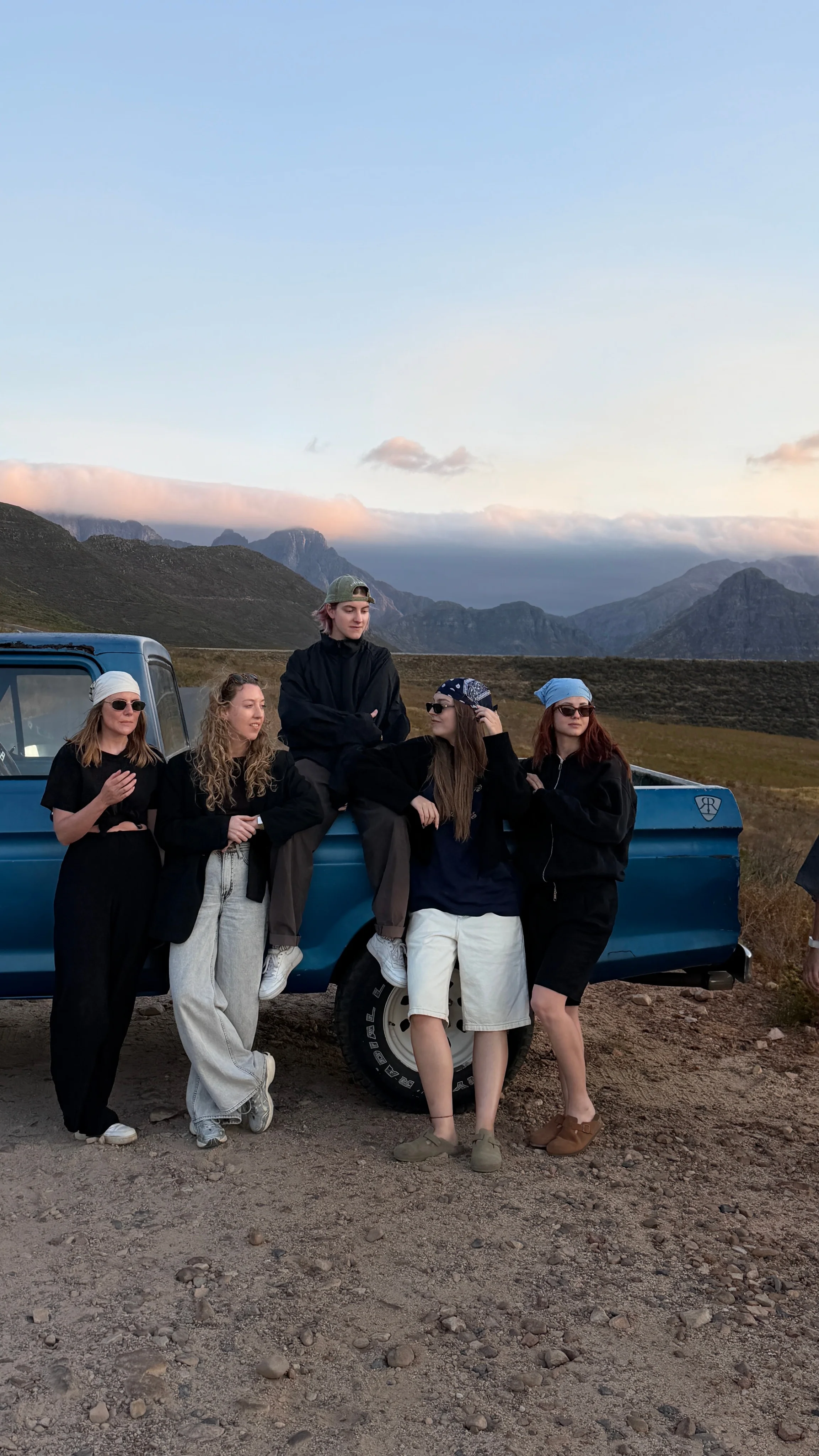 Cast and crew gathered at a pick-up truck in the mountains