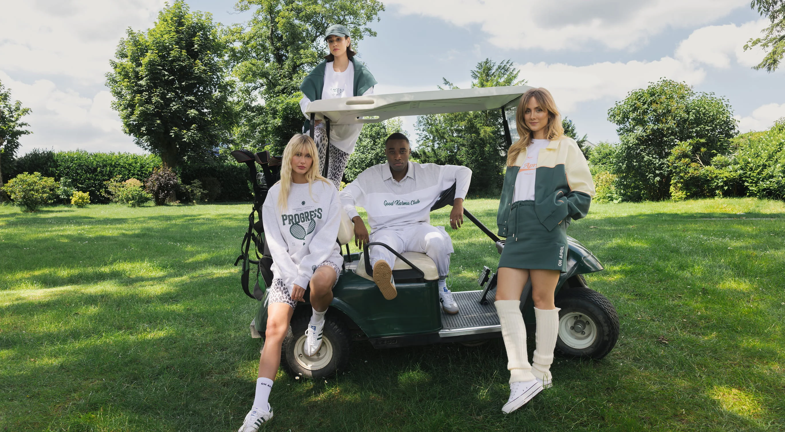 Four people in casual wear by a golf cart