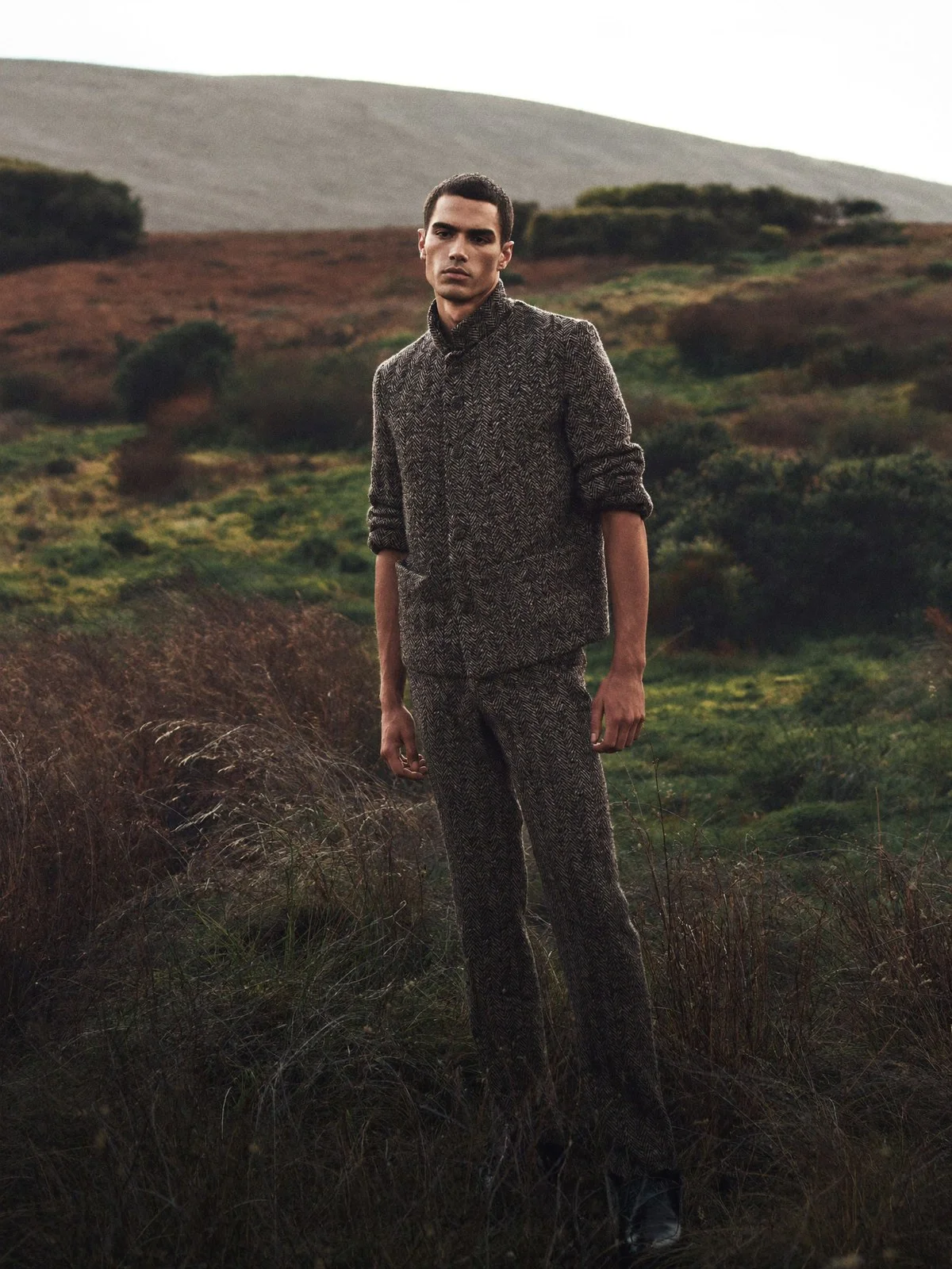 Man in a textured jacket standing in a moorland landscape