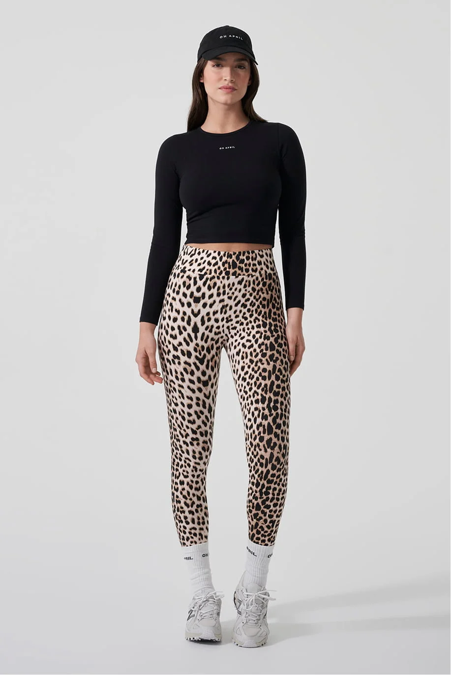 Model in a black top and leopard print leggings, front view