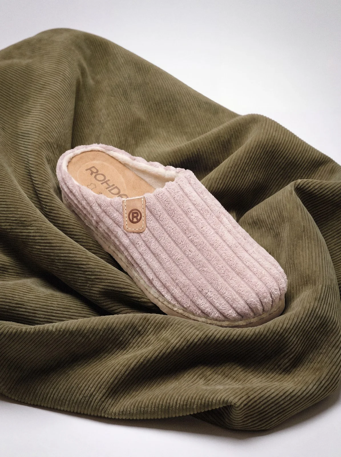 Pink ribbed slipper on olive corduroy fabric