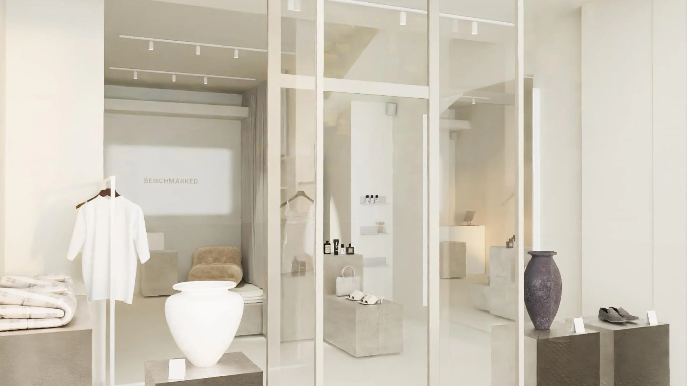 View through the shop window into the pop-up space with a clothing rail, vases and shoes on display
