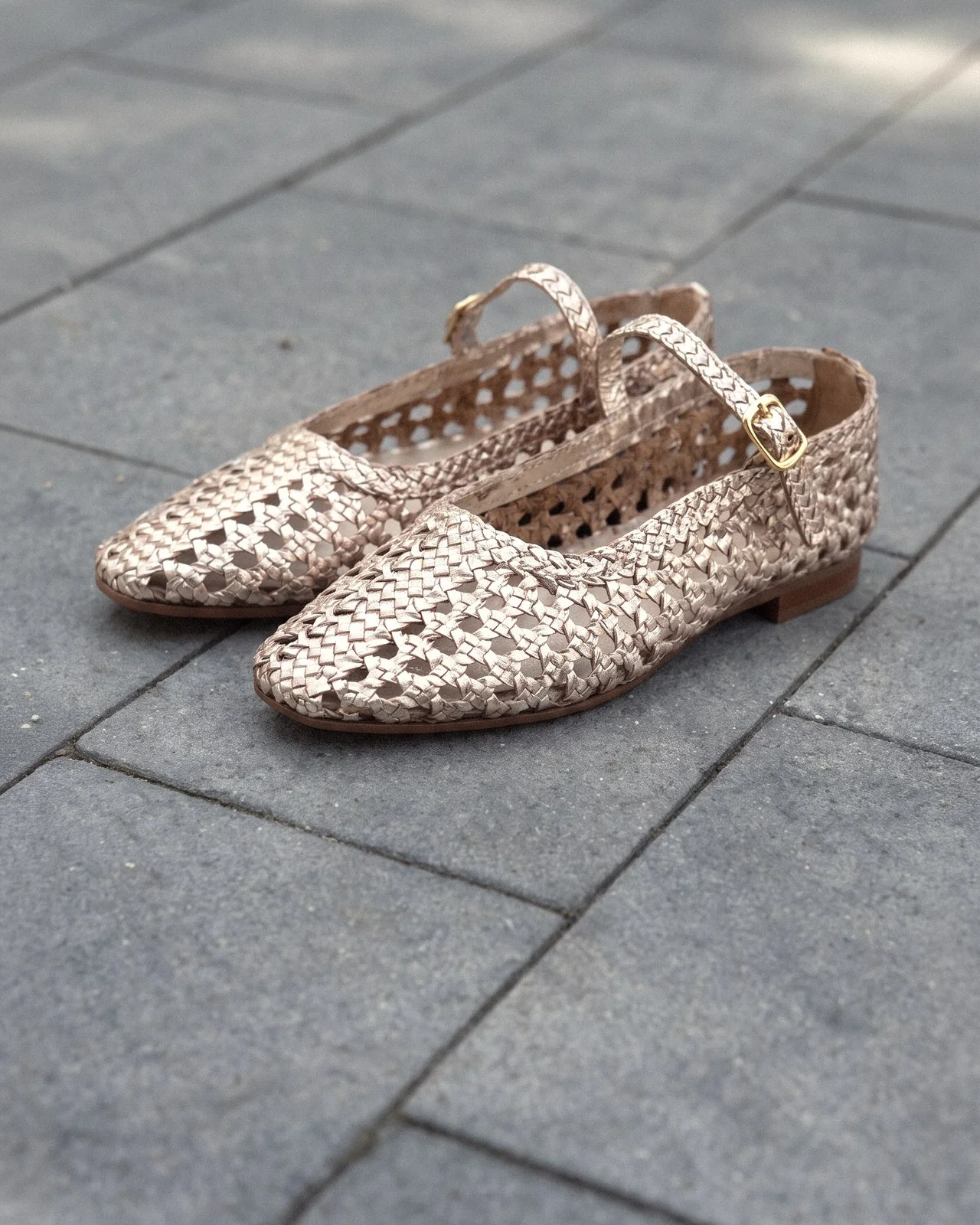 Woven metallic flats on stone paving