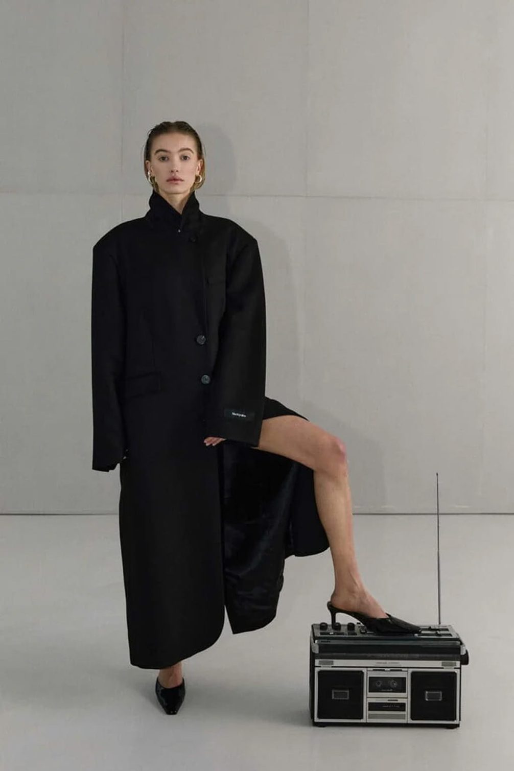 Fashion model with black coat on boombox