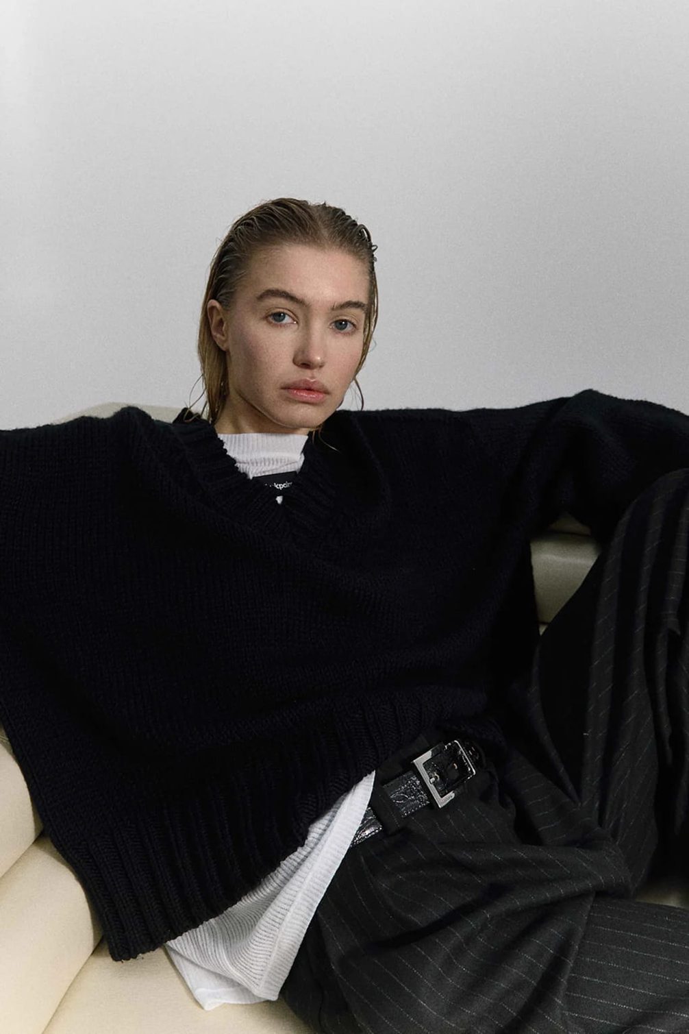 Model in black sweater and pinstripe pants