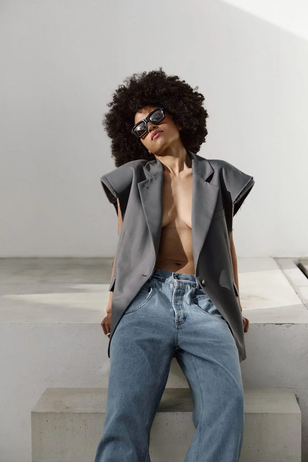 Model with afro wearing sunglasses and oversized blazer