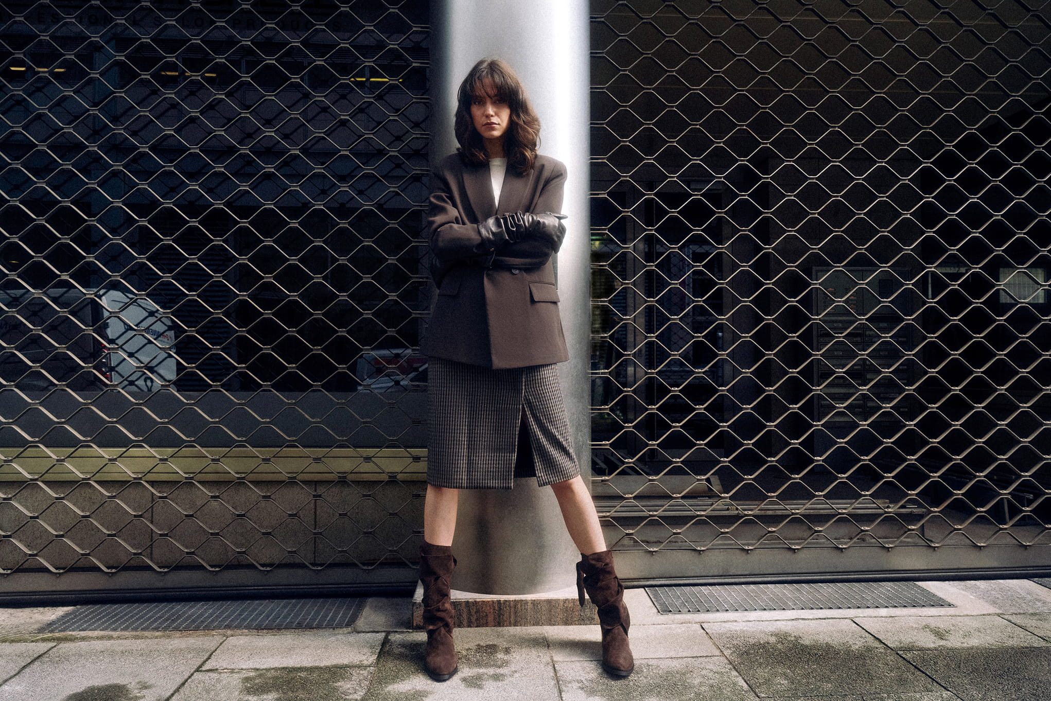 Woman in brown blazer and skirt with gloves