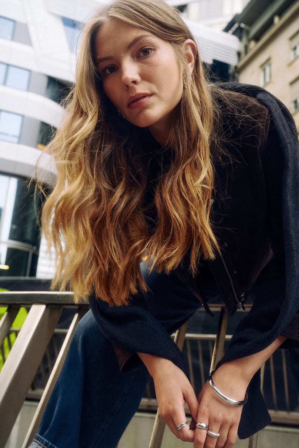 Woman with long blonde hair and jewelry.