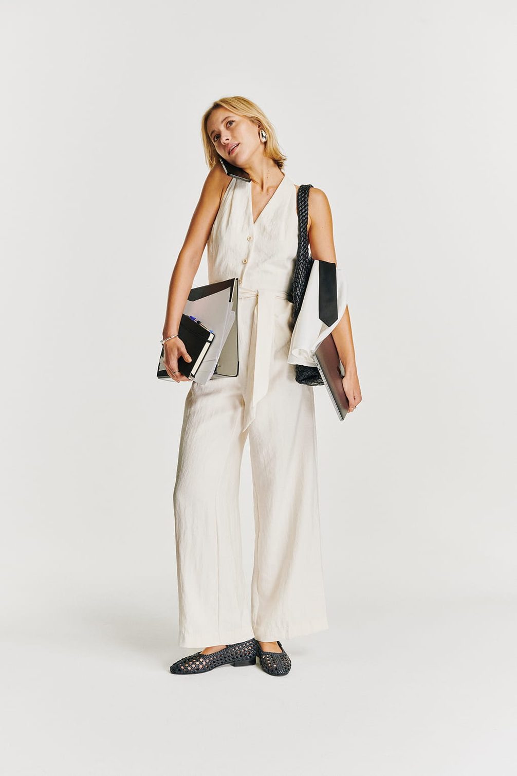 Fashionable woman with phone, laptop, and files.