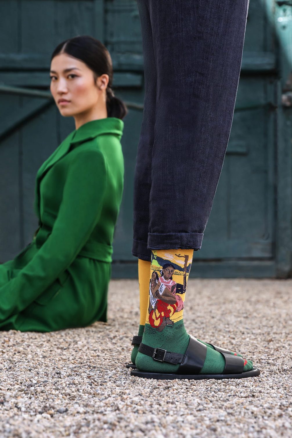 Model in green jacket and patterned socks.