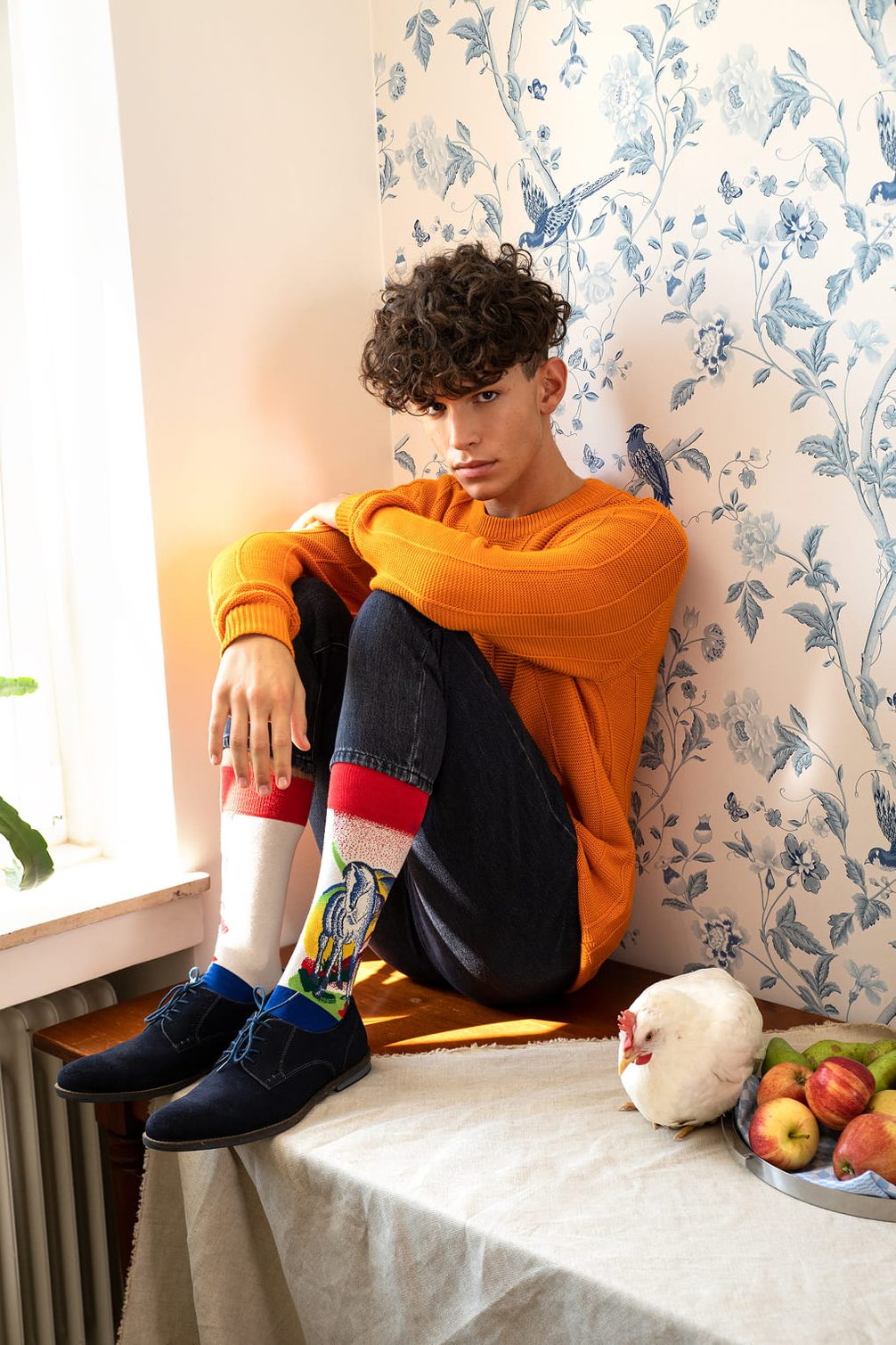 Model in orange sweater & patterned socks