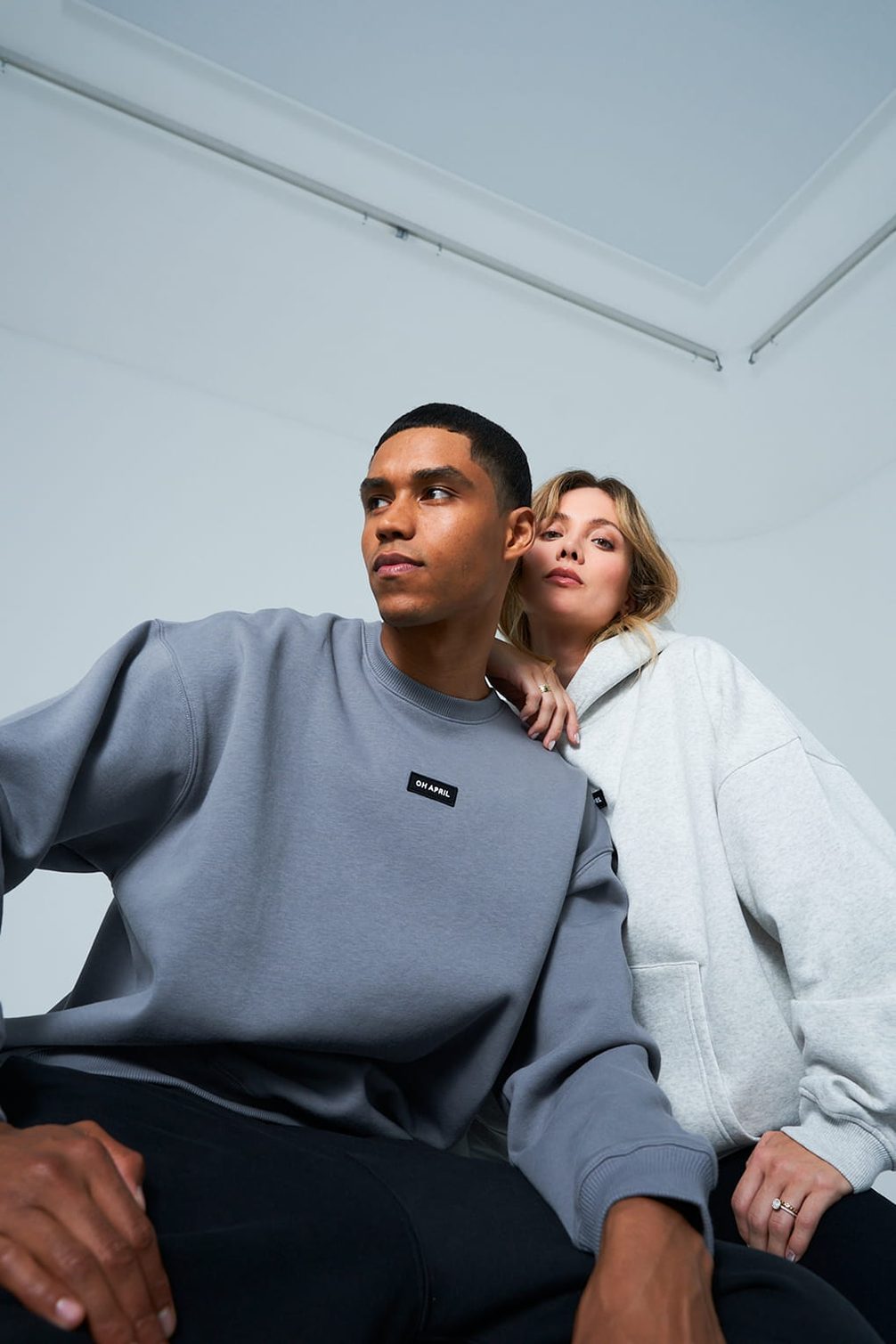 Man in grey sweatshirt, woman in light grey hoodie.