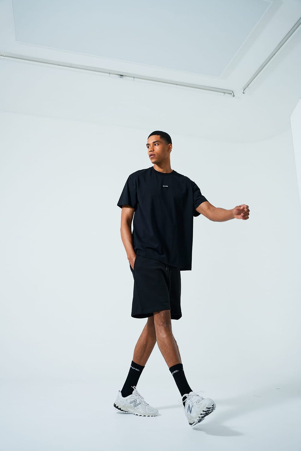 Model in black streetwear on white background