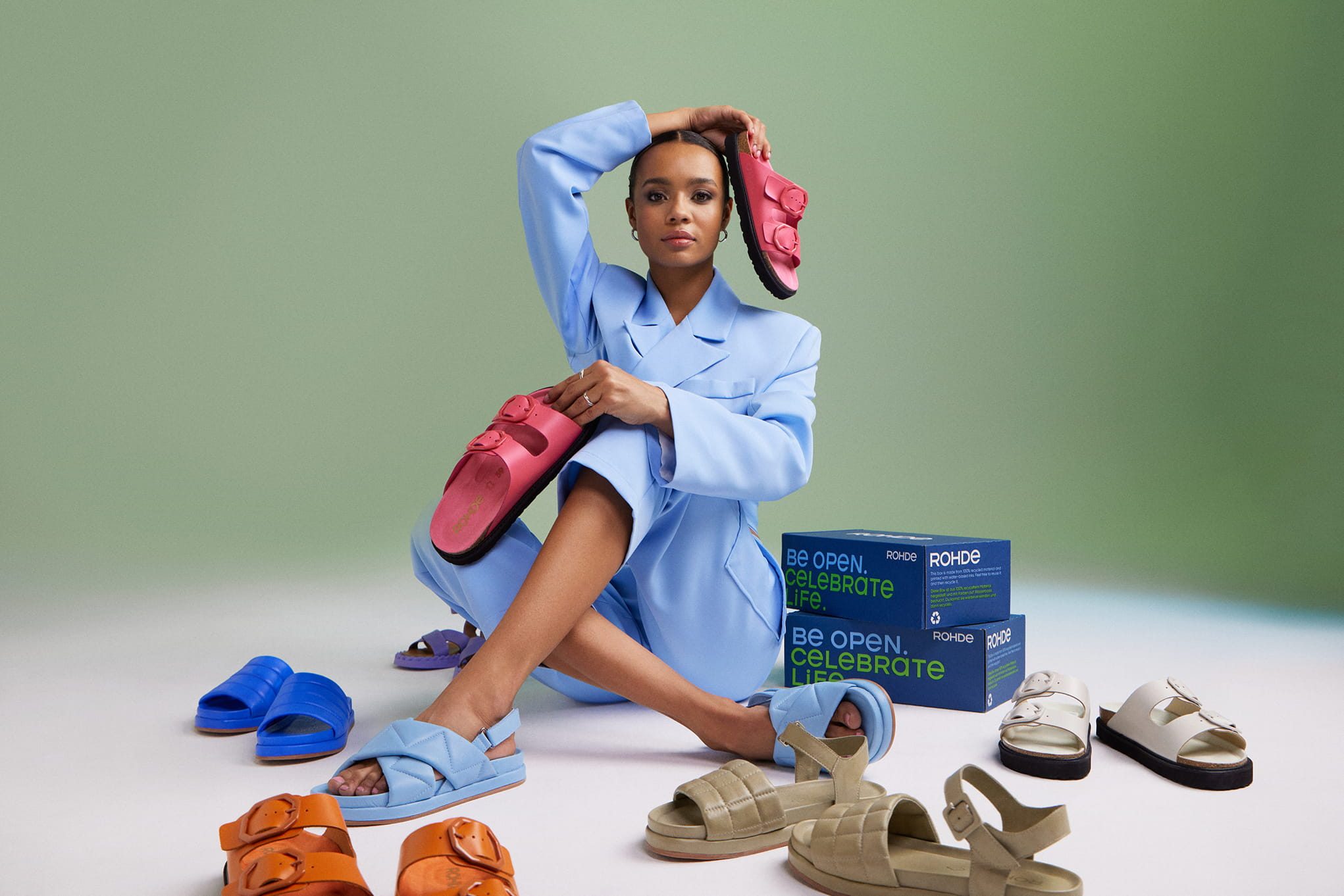 Fashionable woman with colorful Rohde sandals and boxes
