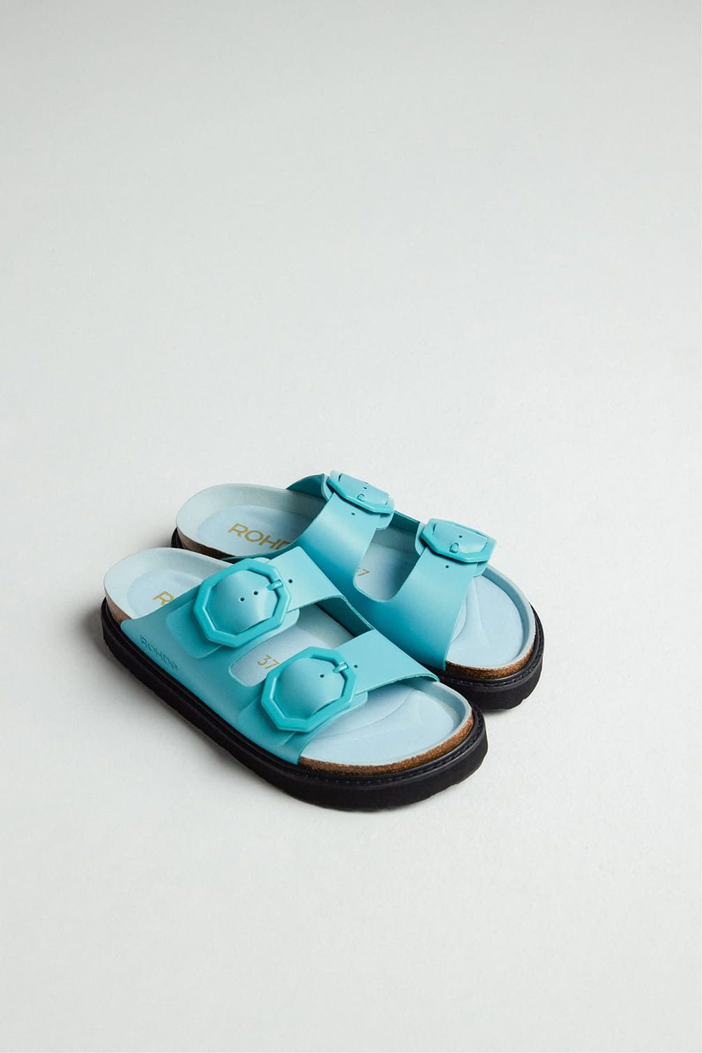 Blue double-strap slides with buckle details, on white background.