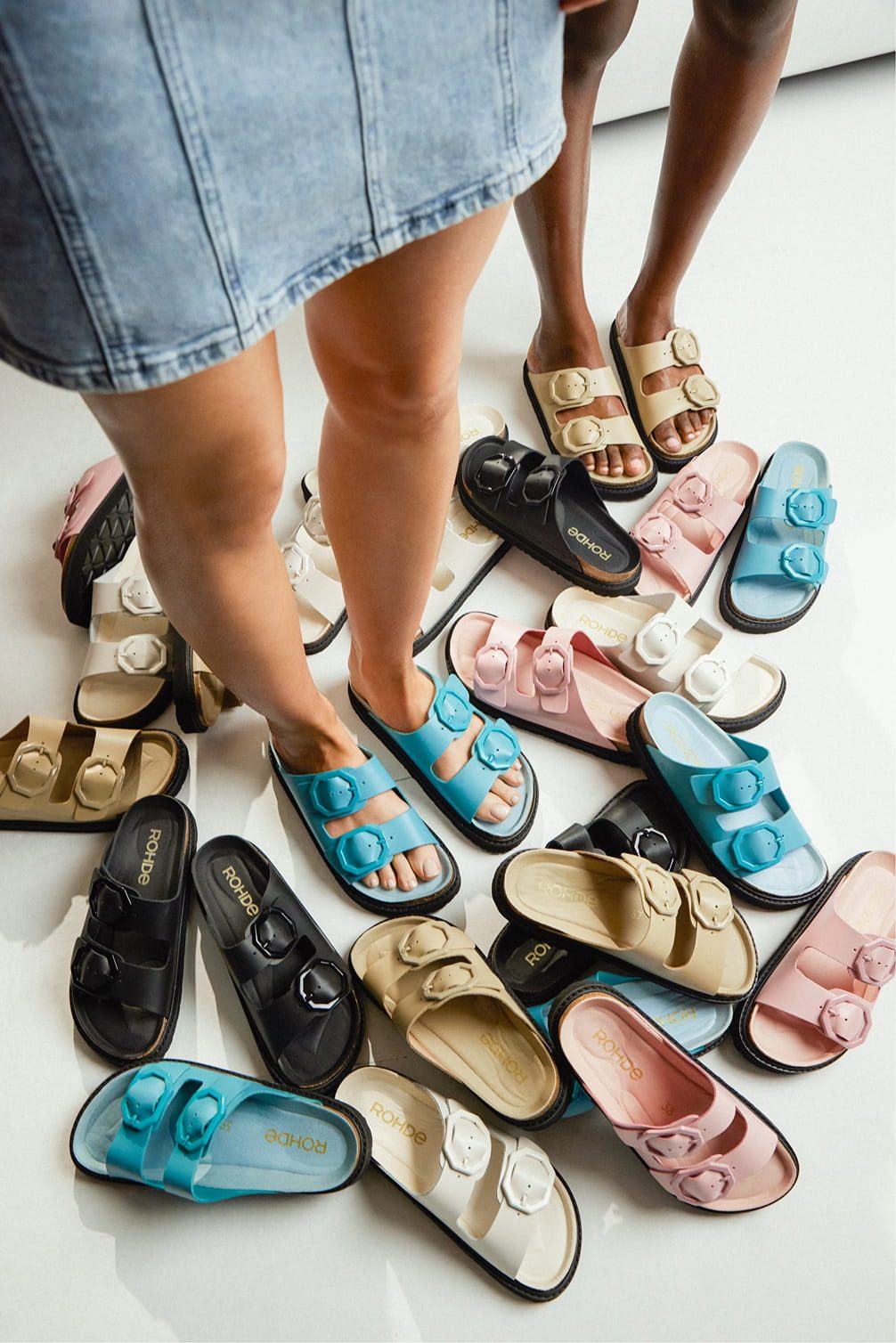 Assortment of colorful slide sandals with buckle details.