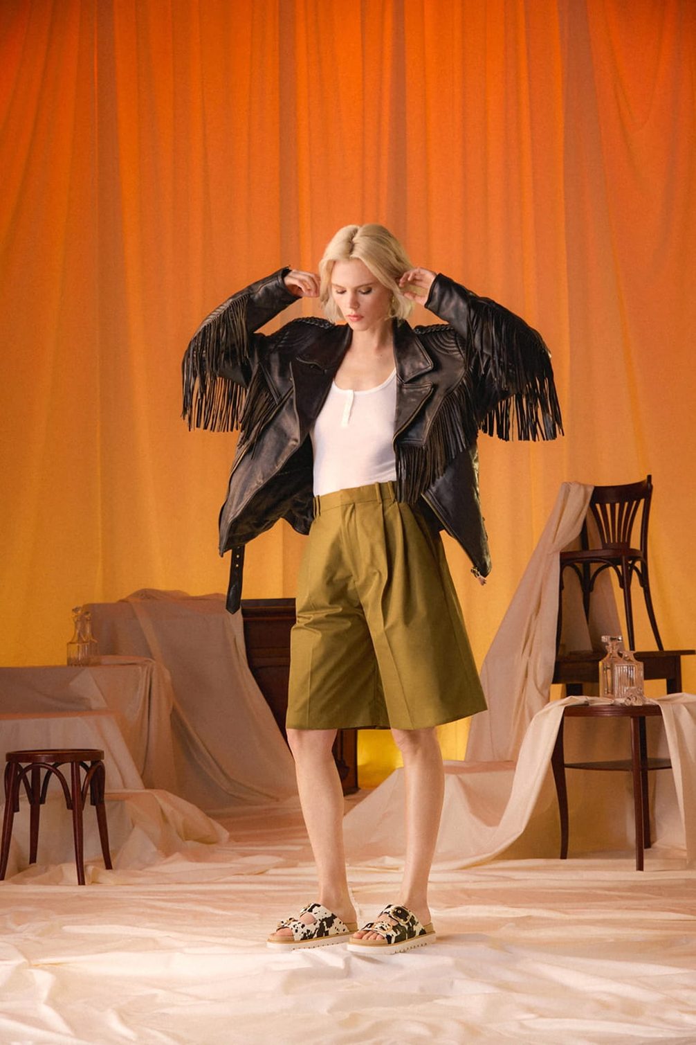 Woman in fringed jacket and olive shorts