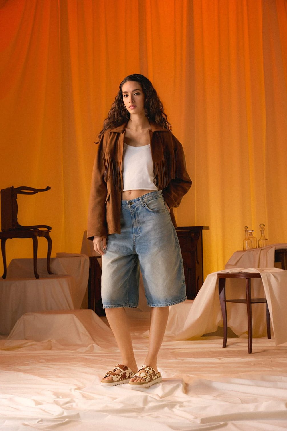 Woman in brown fringed jacket and denim shorts