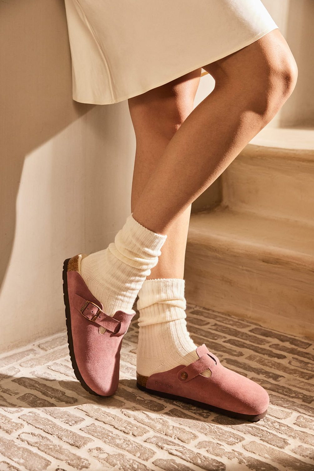 Pink suede clogs with white socks.