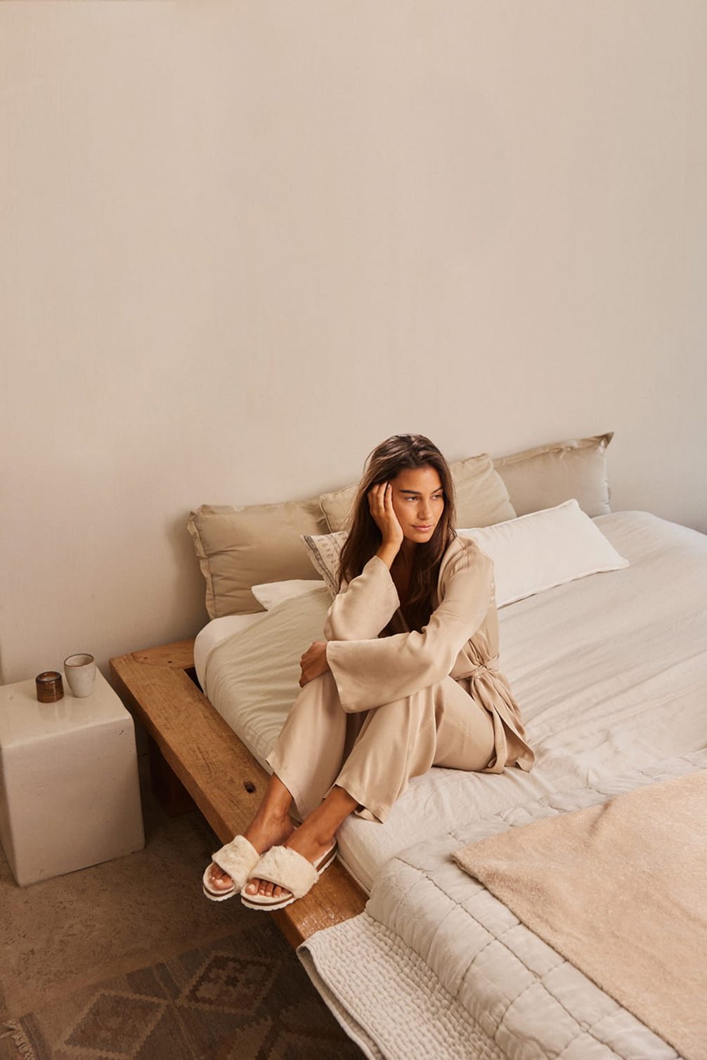 Woman in loungewear relaxing on a bed.