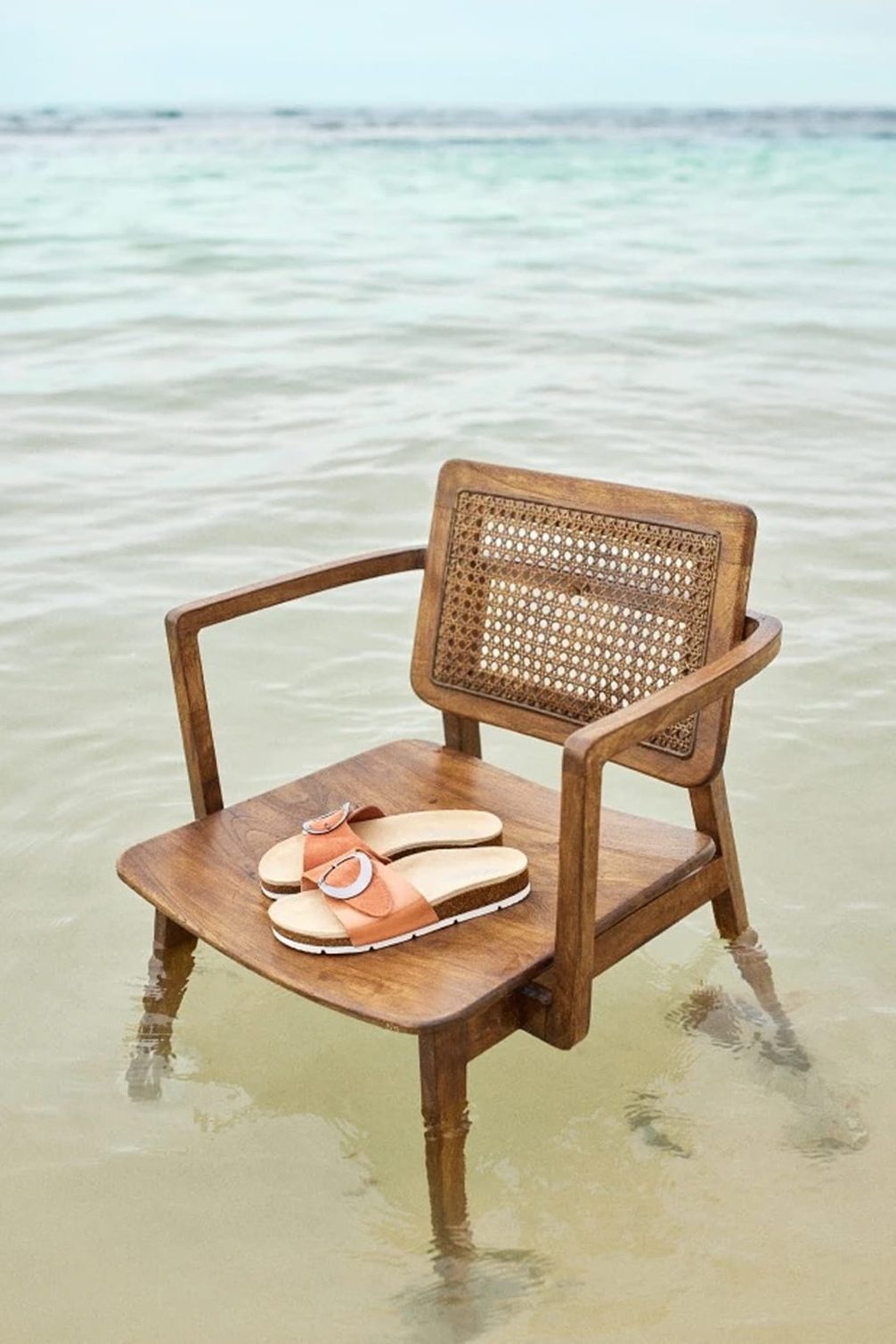 Wooden chair with sandals on water