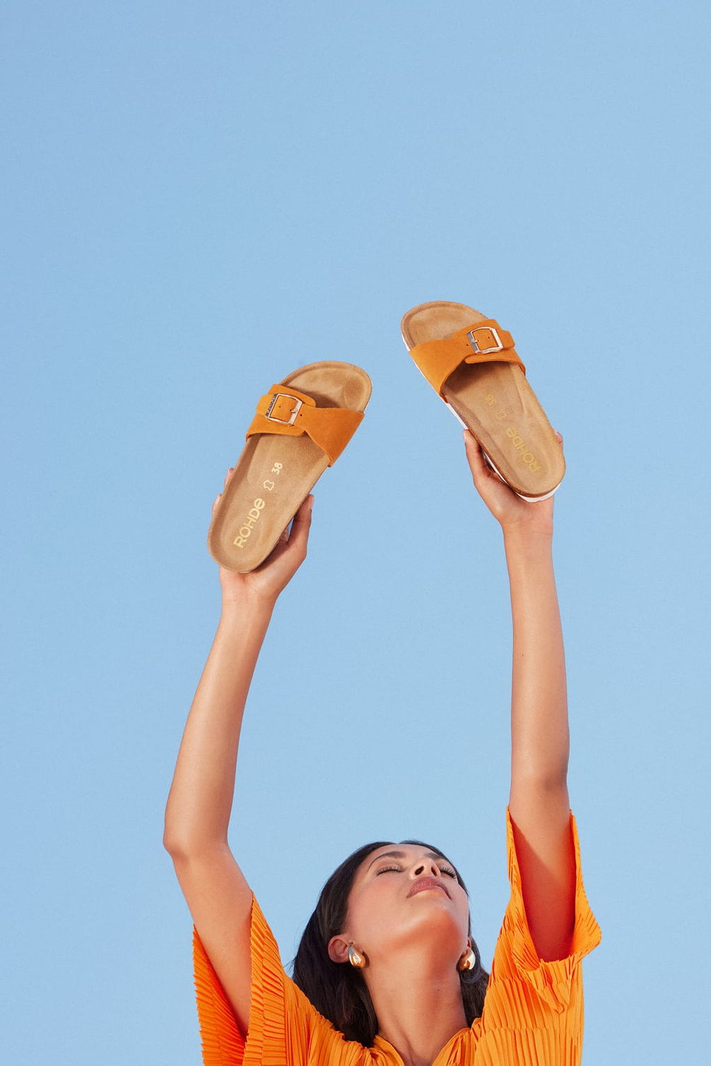 Orange slides held up against blue sky