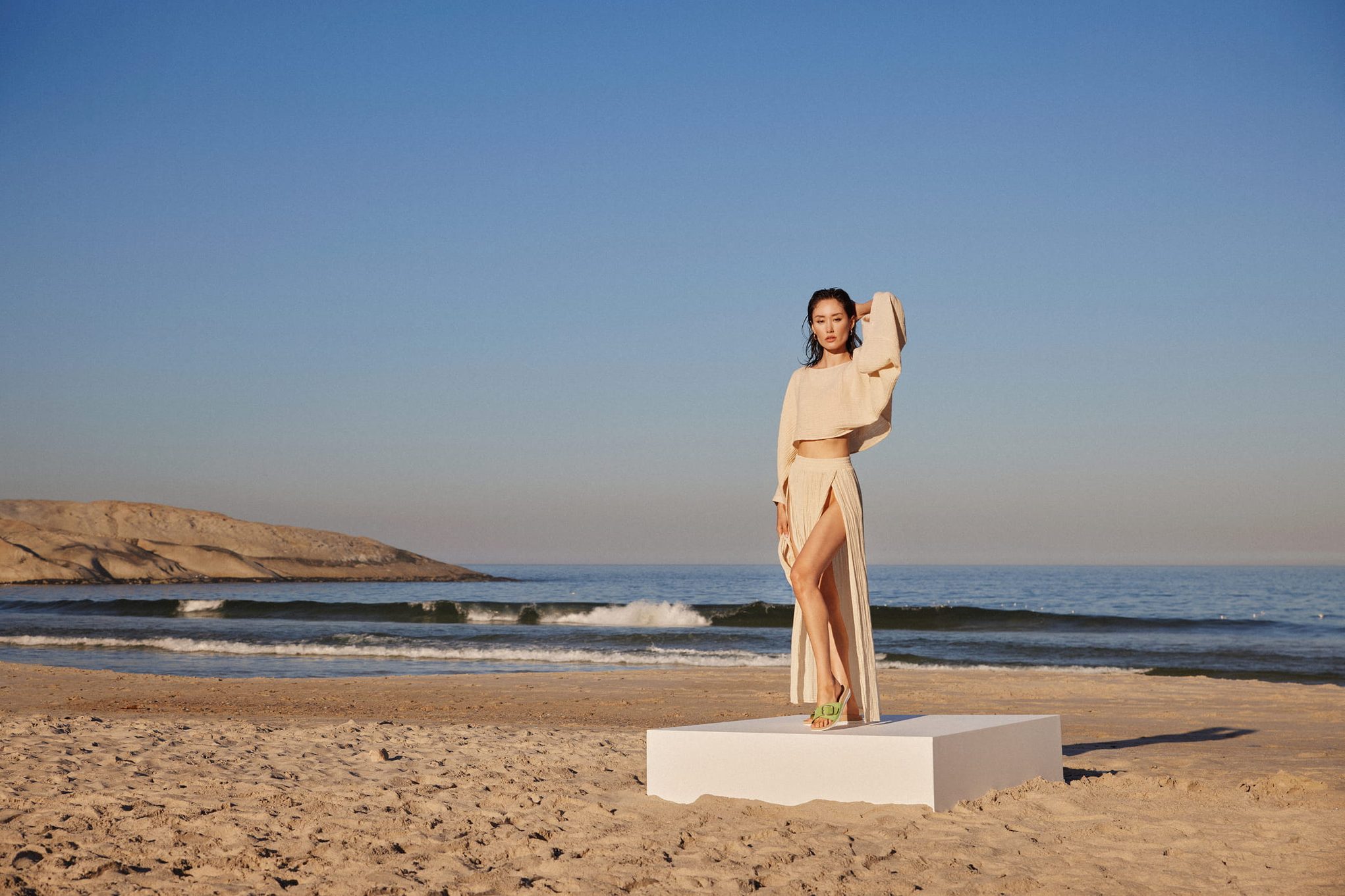 Fashion model on a beach with a sleek outfit.