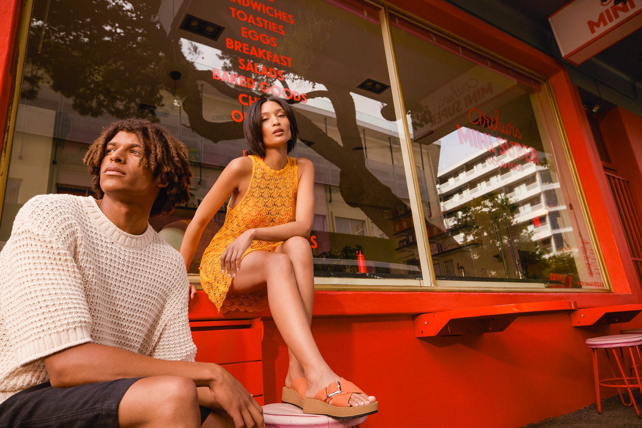 Couple posing in front of a retro diner window.