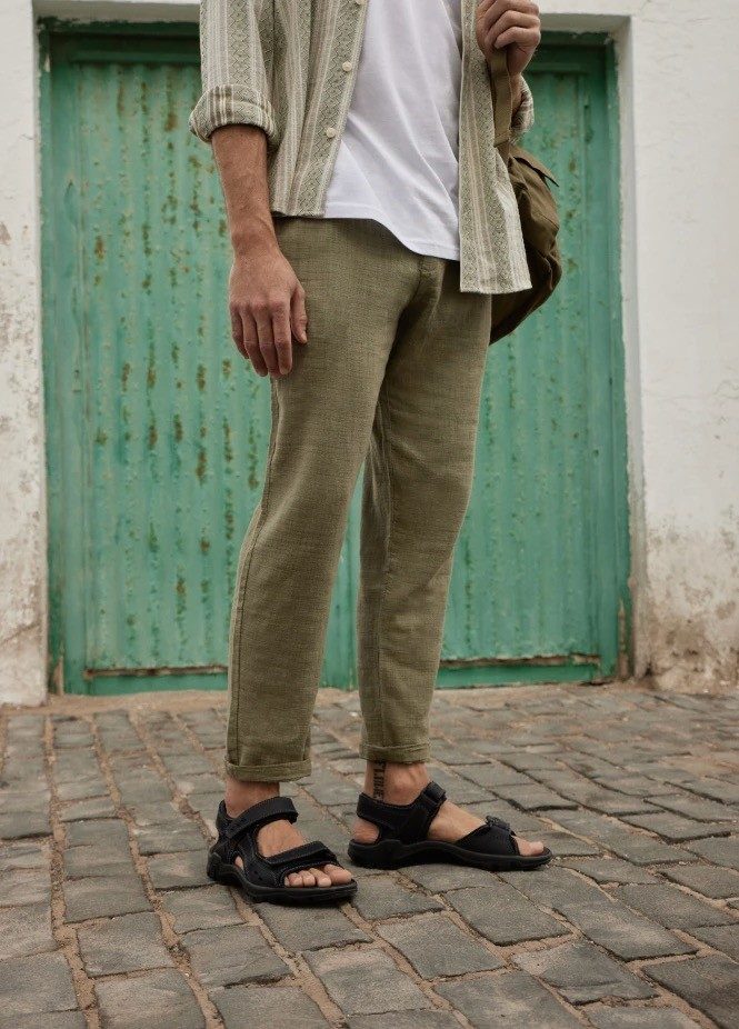 Man wearing green pants and black sandals.