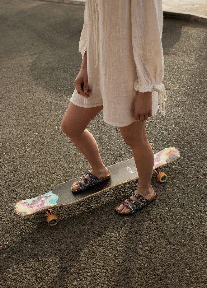 Person standing on skateboard with patterned sandals